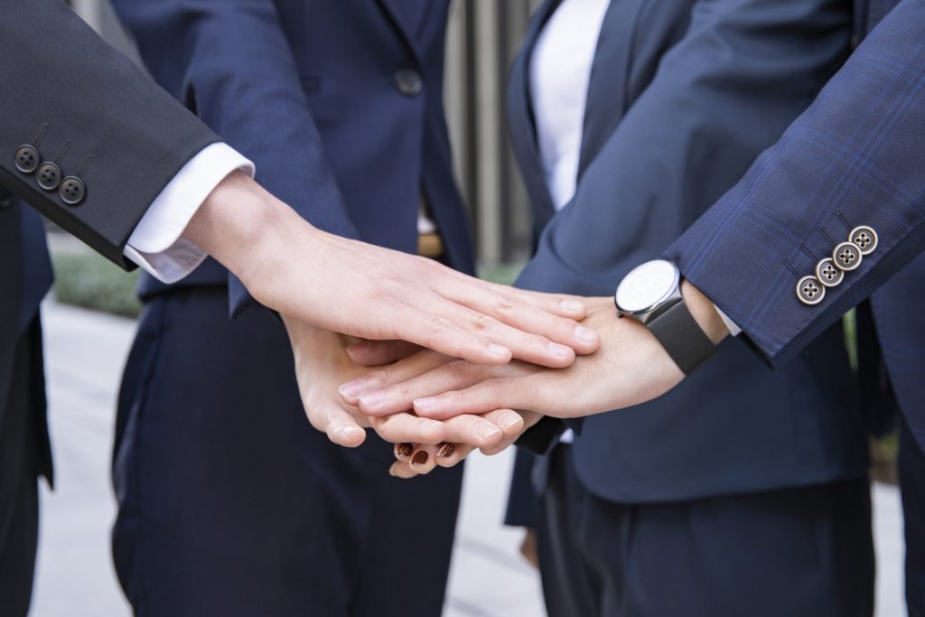 スーツを着た4人で気合い入れ