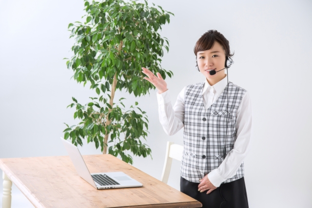 イヤホンマイクを付けているスーツ女性